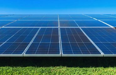 Diverse community members actively collaborating and discussing solar energy projects amidst a vibrant neighborhood backdrop.