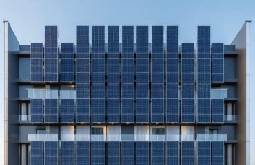 Modern urban building with integrated vertical solar panels on its facade, showcasing energy efficiency and architectural elegance.
