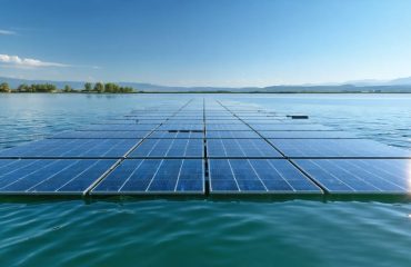 A futuristic floating solar farm with neatly arranged solar panels on a calm lake, capturing sunlight, under a clear blue sky with greenery lining the shore.