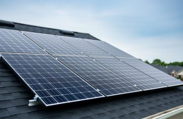 Residential solar panels installed on a roof during bright overcast weather.