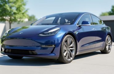 Modern electric vehicle parked outdoors in bright sunlight, highlighting a glossy, protected paint finish near the front fender and hood.